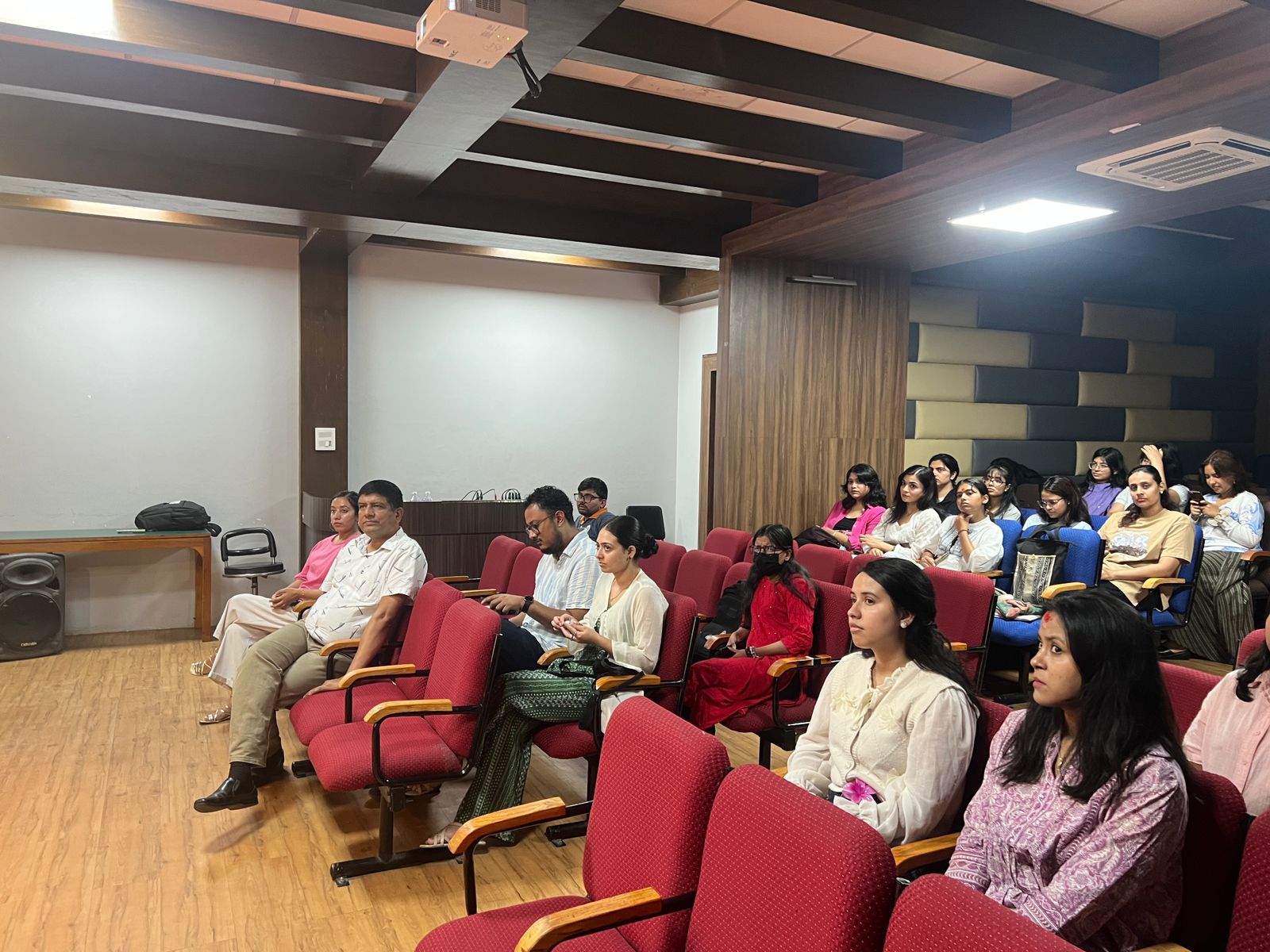 A diverse group of people sits in an auditorium, attentively listening during Q&A session during the documentary screening at National college on August 4.