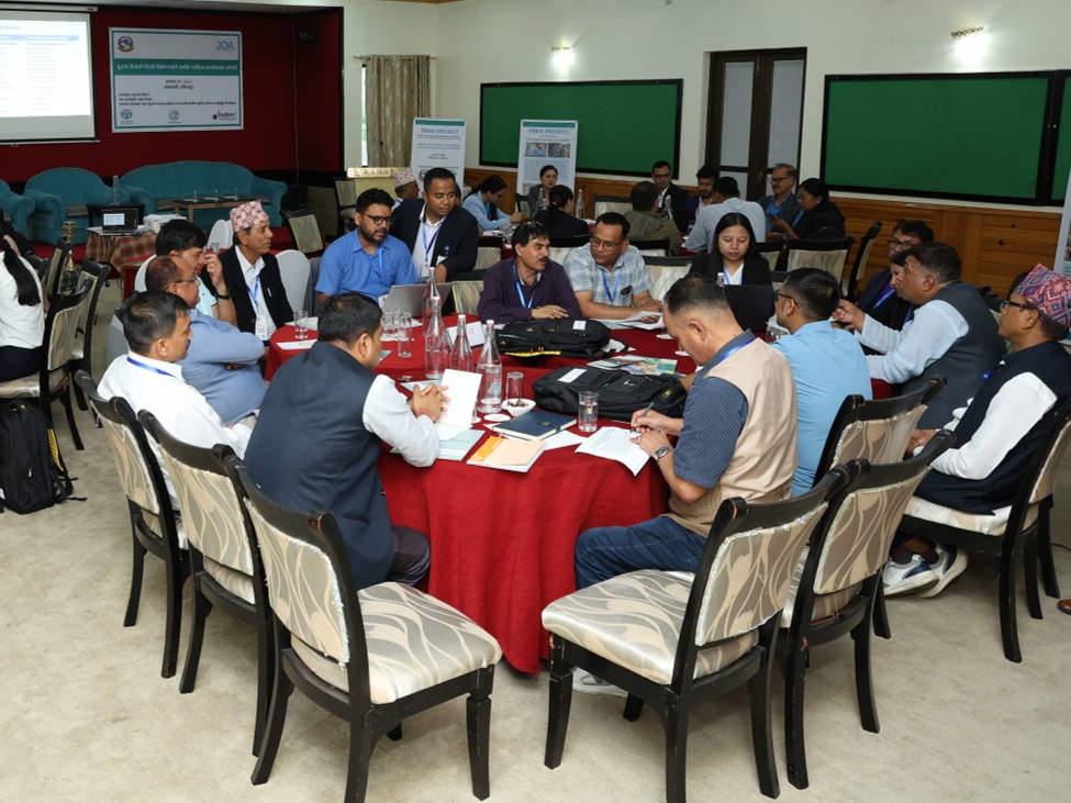 Participants are engaged in discussions at round tables during the National Workshop on Sustainable Dairy Sector Development in a well-lit conference room.